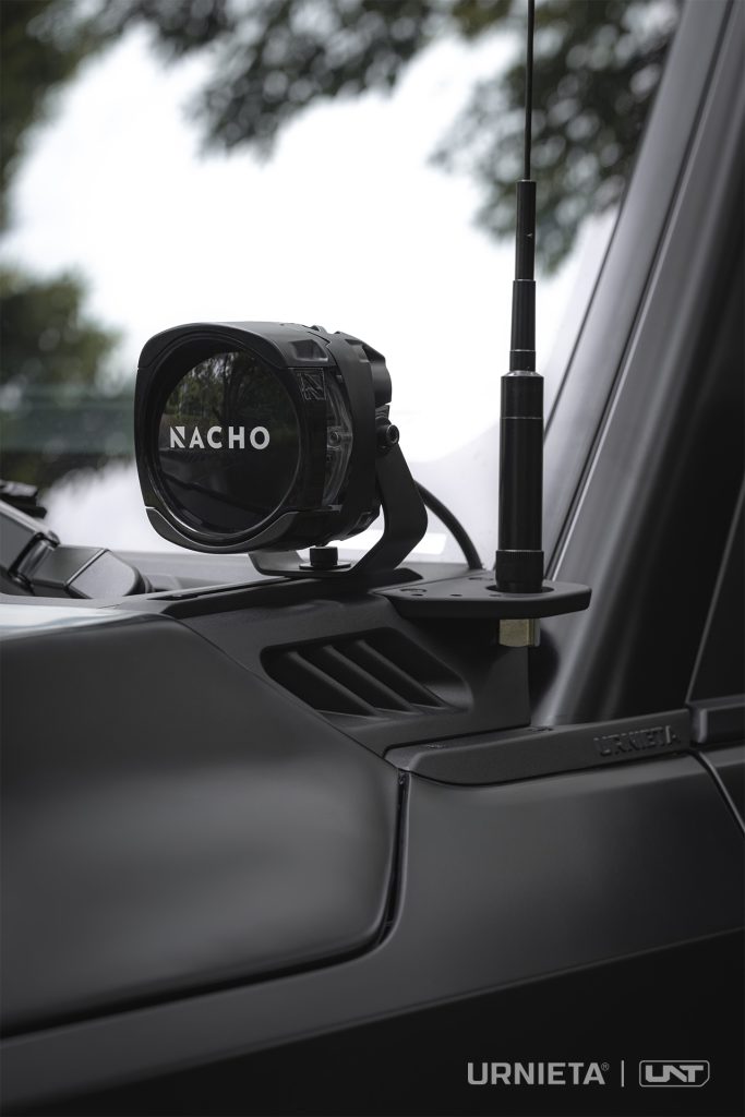 URNIETA LC250 A-Pillar Lighting Brackets on a Toyota Land Cruiser 250, auxiliary light and radio antenna mounted together on the A-pillar bracket in a forest