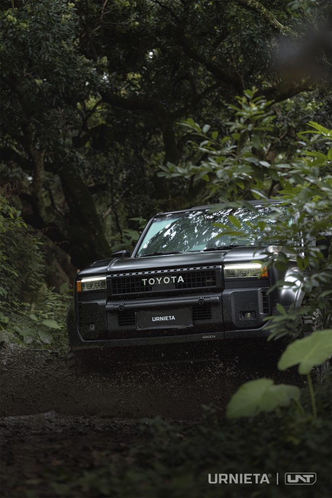 URNIETA LC250 Front Fascia Kit on a Toyota Land Cruiser 250, head-on view beneath overhanging branches on a forest trail