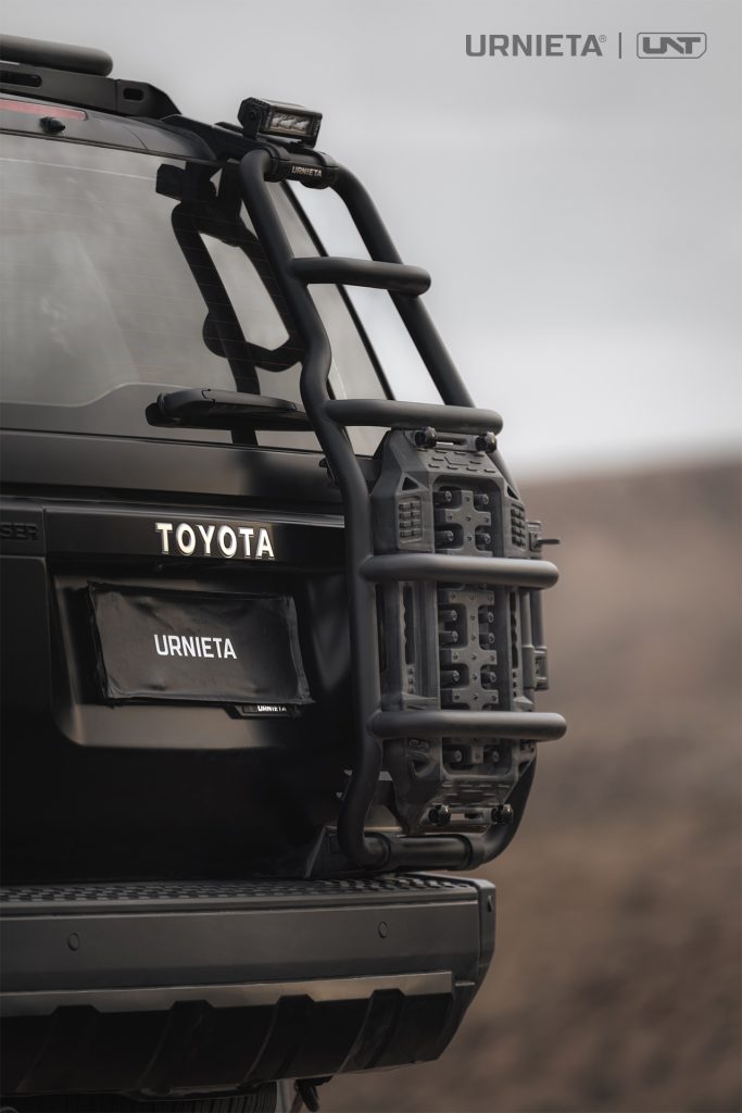 URNIETA Rear Ladder Kit for Land Cruiser 250, rear view with recovery board on the ladder against a desert sky